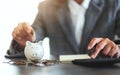 A woman putting coins in a piggy bank and calculating with calculator for saving money and financial concept Royalty Free Stock Photo