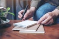 A woman`s hand preparing to write on blank notebook