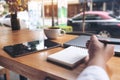 Closeup image of woman`s hand writing on a blank notebook with laptop , tablet Royalty Free Stock Photo