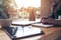 Closeup image of woman`s hand writing on a blank notebook with laptop , tablet and coffee cup on wooden table Royalty Free Stock Photo