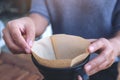 A woman`s hands setting a filter to make a drip coffee