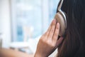 A woman turn back , using and holding headphone with feeling relax in modern cafe