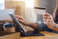 A woman using tablet pc and credit card for online shopping with postal parcel box and shopping bags on the table Royalty Free Stock Photo