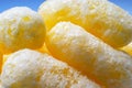 Closeup Image of Yellow Corn Puffs on Blue Background. Crunchy Flavored Puffed Snacks. Party, Movie, TV, Game Snacks