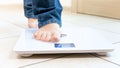 Closeup image of young barefoot walking on weight scales