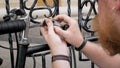 Closeup image of young man locking bicucle with combination lock