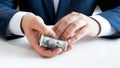 Closeup image of young man in suit holding big stack of US dollars in hands