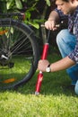 Closeup image of young man using air pump to fix flat bicycle tyre Royalty Free Stock Photo