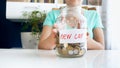 Closeup photo of young woman holding glass jar full of money for buying new car Royalty Free Stock Photo