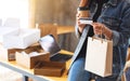 A young woman holding and using credit card for online shopping with tablet pc and postal parcel box on the table Royalty Free Stock Photo