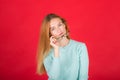 Closeup image of young woman 20s wearing black t-shirt taking off glasses and looking aside in surprise, isolated over red Royalty Free Stock Photo