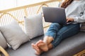 A young woman using and working on laptop computer while lying on a sofa at home Royalty Free Stock Photo