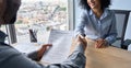 Newcomer worker female African American and Indian ceo shaking hands.