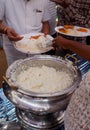 Closeup of Indian street food vendor serving cooked rice from bowl