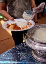 Closeup of Indian street food vendor serving cooked rice from bowl