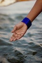 Closeup of an Indian woman's hand with blue bangles touching the river water Royalty Free Stock Photo