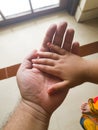 Closeup indoor photo of a Child& x27;s hand on an adult& x27;s hand