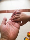Closeup indoor photo of a Child's hand holding an adult's hand in the natural day light