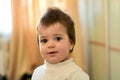 Closeup indoor portrait of a baby boy with naughty hair. The various emotions of a child.