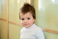 Closeup indoor portrait of a baby boy with naughty hair. The various emotions of a child.