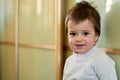 Closeup indoor portrait of a baby boy with naughty hair. The various emotions of a child.