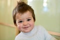 Closeup indoor portrait of a baby boy with naughty hair. The various emotions of a child.