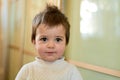 Closeup indoor portrait of a baby boy with naughty hair. The various emotions of a child.