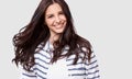 Closeup indoor portrait of beautiful brunette young woman with long hair smiling cheerfully. Royalty Free Stock Photo