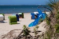 Closeup of an inflatable dolphin and empty roofed wicker beach chairs on a sandy beach Royalty Free Stock Photo