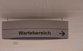 Closeup of an Information sign arrowing in the waiting room in a hospital written in german