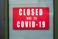 Information sign on the metallic window of the store front : Closed due to covid-19