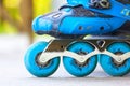 Closeup of inline roller skates with blue wheels.