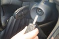 Closeup inside vehicle of hand holding key in ignition, start engine key