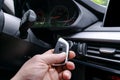 Closeup inside vehicle of man hand holding wireless key ignition. Start engine key. Hand holding car key remote. Modern car backgr Royalty Free Stock Photo