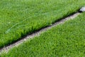 Closeup installation of football field with artificial turf with grass. Close up of line of an artificial football field. Details