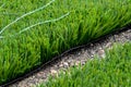 Closeup installation of football field with artificial turf with grass. Close up of line of an artificial football field. Details