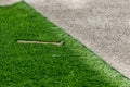 Closeup installation of football field with artificial turf with grass. Close up of line of an artificial football field. Details