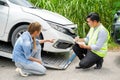 Closeup insurance company officers post a list of repairs on work list clipboard according sufferer woman point out the damage on