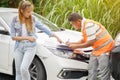 Closeup insurance company officers post a list of repairs on work list clipboard according sufferer woman point out with her car