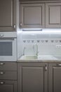 Closeup interior of kitchen room with sink, faucet and wooden cupboards