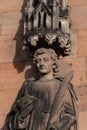 Closeup of intricately carved stone statue mounted above a brick wall in Lichfield Cathedral, UK