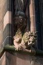 Closeup of intricately carved stone statue mounted above a brick wall in Lichfield Cathedral, UK