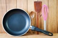 Closeup of iron frying pan and wooden utensils