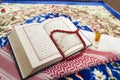Closeup of Islamic book Quran rosary and shemagh scent on colorful prayer mat,religious concept Royalty Free Stock Photo