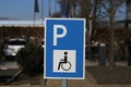 Closeup of isolated blue white reserved for disabled people parking space sign, blurred background Royalty Free Stock Photo