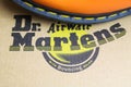 Closeup of isolated cardboard shoe box with dr martens label lettering and part of orange color boot with black sole