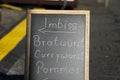 Closeup of isolated chalk board on street showing direction to snack stand with Pommes, currywurst and bratwurst