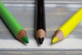 Closeup of isolated colorful black, green, yellow crayons on wood background - jamaica coalition concept