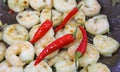 Closeup of isolated oil fried spicy fresh tiger shrimps in wok pan with shiny red chili peppers Royalty Free Stock Photo