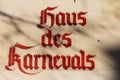 Closeup of isolated red text lettering haus des Karnevals house of carnival on building wall